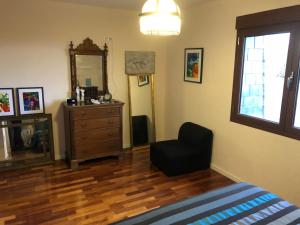 a bedroom with a dresser and a chair and a mirror at El Refugio. in Teruel +18 photos
