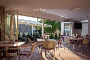 a restaurant with tables and chairs and a patio at Iris SMART Boutique Self Check-in 24h in Otopeni