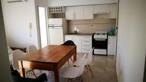 cocina con mesa de madera y armarios blancos en Depto 34 y 25, hasta 5 pasajeros, amplio y luminoso en La Plata