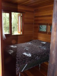 a bedroom with a bed in a wooden cabin at Recanto na Montanha de Gramado in Gramado