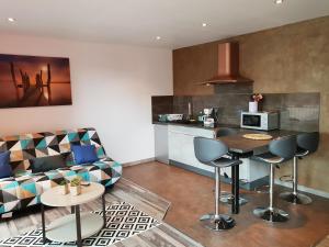 uma cozinha e sala de estar com um sofá e uma mesa em Beaux lofts près d'Europa Park et Strasbourg em Obenheim