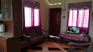 een woonkamer met een tv, een bank en ramen bij LOT7040 in Melaka