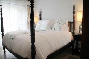 1 dormitorio con 1 cama grande con sábanas y almohadas blancas en Los Suenos Resort Veranda 2B by Stay in CR, en Herradura