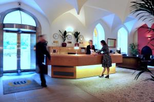 two people standing at a reception desk in a lobby at The Coach House at Missenden Abbey in Great Missenden