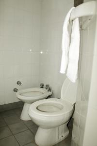 a white bathroom with a toilet and a bidet at Avenida Hotel in Junín