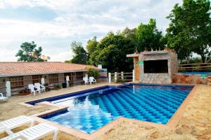 a swimming pool with chairs and a house at Hotel Boutique Santa Clara Mesa de los Santos in Los Santos