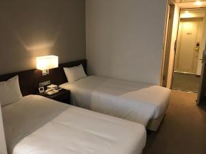Postel nebo postele na pokoji v ubytování Chisun Hotel Kamata