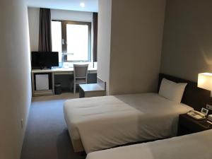 Postel nebo postele na pokoji v ubytování Chisun Hotel Kamata