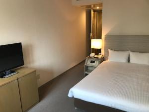 Postel nebo postele na pokoji v ubytování Chisun Hotel Kamata