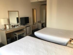 Postel nebo postele na pokoji v ubytování Chisun Hotel Kamata