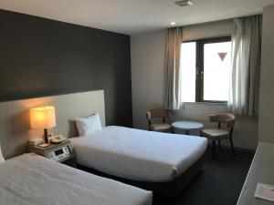 Postel nebo postele na pokoji v ubytování Chisun Hotel Kamata