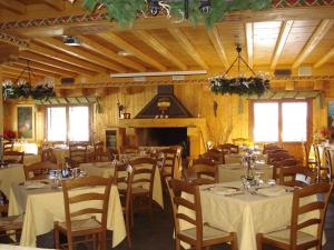a dining room with tables and chairs and a fireplace at Hotel Chamois d'Or in Tende