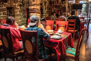 dos personas sentadas en una mesa en un restaurante en Eureka Lodge en Ollantaytambo