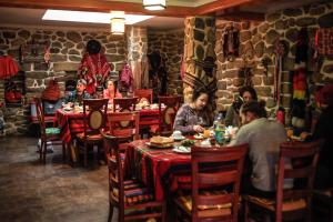 a group of people sitting at tables in a restaurant at Eureka Lodge in Ollantaytambo