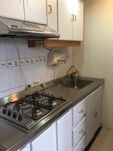 een keuken met een fornuis en een wastafel bij Apt estudio calle97302 in Bogota