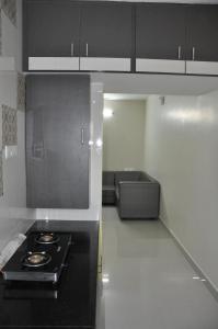 cocina con fogones negros en una habitación en Moonlight Residency, en Tiruchchirāppalli