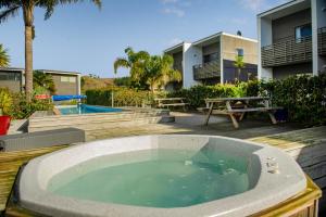 a hot tub on a deck next to a house at Aqua Soleil Villas in Whitianga