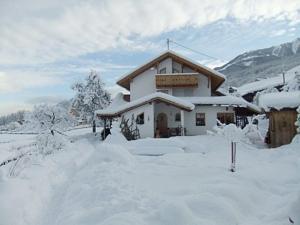 un edificio cubierto de nieve delante en Apart Auszeit, en Arzl im Pitztal