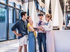 un gruppo di persone che guarda un portatile di HOTEL CHAM CHAM - Taipei a Taipei