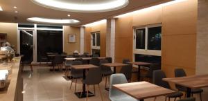 a restaurant with wooden tables and chairs and windows at New California in Xindian