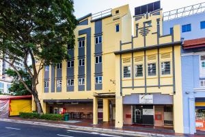 un edificio amarillo en una calle de la ciudad en Fragrance Hotel - Rose, en Singapur
