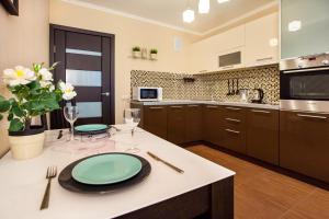 トリヤッチにあるVanilla Sky Apartment SUTKI LIFEのキッチン(緑の皿が並ぶテーブル付)