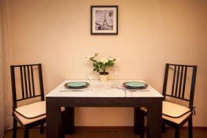 トリヤッチにあるVanilla Sky Apartment SUTKI LIFEのテーブル(椅子2脚付)、テーブル(皿2皿、花付)