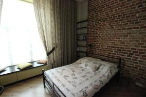 a bed in a room with a brick wall at Loft Niezapominajka w Tobaco Park in Łódź