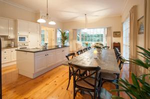 a kitchen with a long table and chairs in a room at Moulton Park Estate - Homestead in Sassafras
