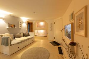 ein Wohnzimmer mit einer weißen Couch und einem Teppich in der Unterkunft Ferienwohnung Gerberstube, 100m vom See in Überlingen