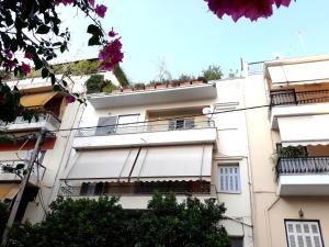 an apartment building with flowers on the balconies at You can almost smell the sea! in Athens