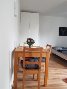 a wooden table and chair with a vase of flowers on it at Wurmberg Domizil in Braunlage
