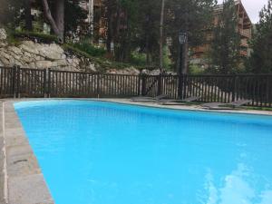 a large blue swimming pool next to a fence at Les Arcs 1950 - appartement 6 pers. in Arc 1950