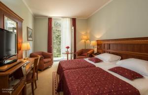 a hotel room with a bed and a flat screen tv at Boutique Hotel Korana Srakovcic in Karlovac