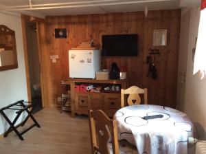 ein Esszimmer mit einem Tisch und einem TV in der Unterkunft La Bergerie - chalet Alice in Choex