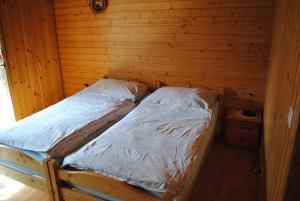 Bett in einem Holzzimmer mit zwei Kissen in der Unterkunft Studio Glaus in Wilderswil
