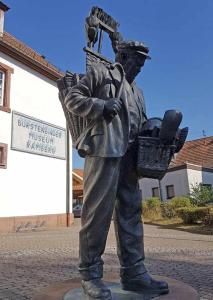 une statue d'un homme tenant un panier dans l'établissement Haus 3 Birken, à Ramberg