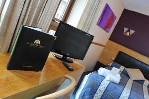 a desk with a computer on top of a bed at The Coach House at Missenden Abbey in Great Missenden