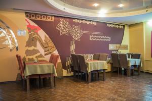 a restaurant with tables, chairs and tables at Voyage Hotel in Sheregesh