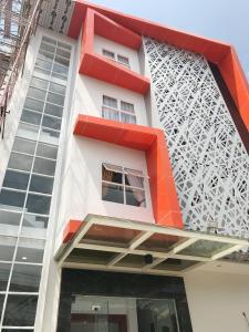 a building with a red and white facade at Cemerlang Inn in Palembang
