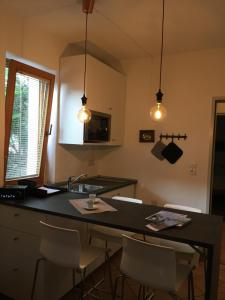 a kitchen with a black counter and a kitchen island with chairs at Appartement Rainer Sistrans in Innsbruck