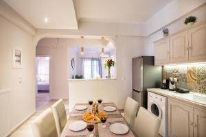 una cucina e una sala da pranzo con tavolo e sedie di Penelope Corfu Suite a Città di Corfù