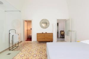 biała sypialnia z komodą i lustrem w obiekcie Villa Aurelia - guesthouse Le Case di Aurelia w mieście Castellana Grotte