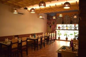 Un comedor con mesas, sillas y luces. en Hotel Hari Vilaas, en Varanasi