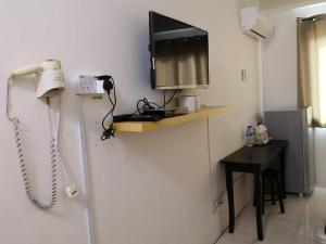 a room with a phone and a tv on the wall at Fun Studio Pangkor in Pangkor
