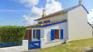 Casa blanca pequeña con ventanas azules y techo en Réf 227 Seignosse , à proximité immédiate de la plage des Bourdaines , villa patio classée 3 étoiles , 6 personnes, en Seignosse