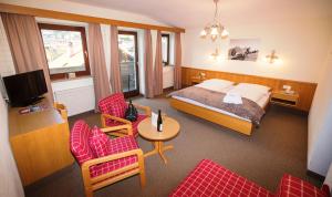 une chambre d'hôtel avec un lit, une table et des chaises dans l'établissement Hotel zum Lamm, à Tarrenz