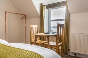 a bedroom with a table and chairs and a window at The Old School House B&B in Gairloch +21 photos