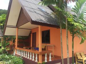 a guest house with a balcony and palm trees at El Greco Bungalows Koh Lanta in Ko Lanta