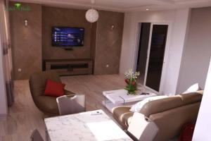 a living room with a couch and a tv at Appart M'Rode Baguida in Lomé